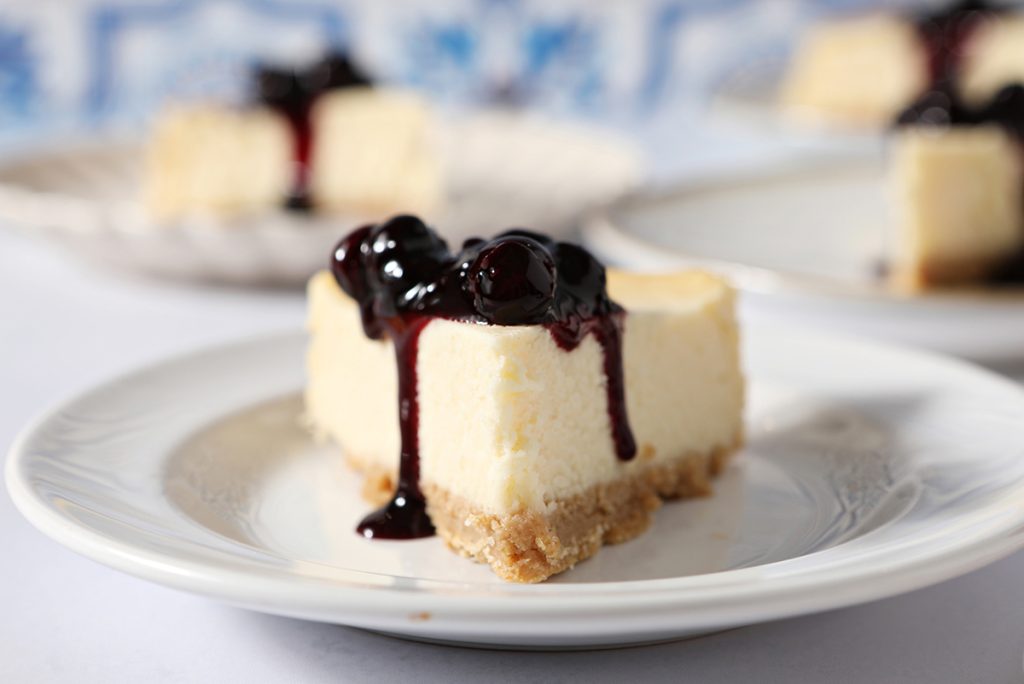 slice of cheesecake topped with blueberry sauce