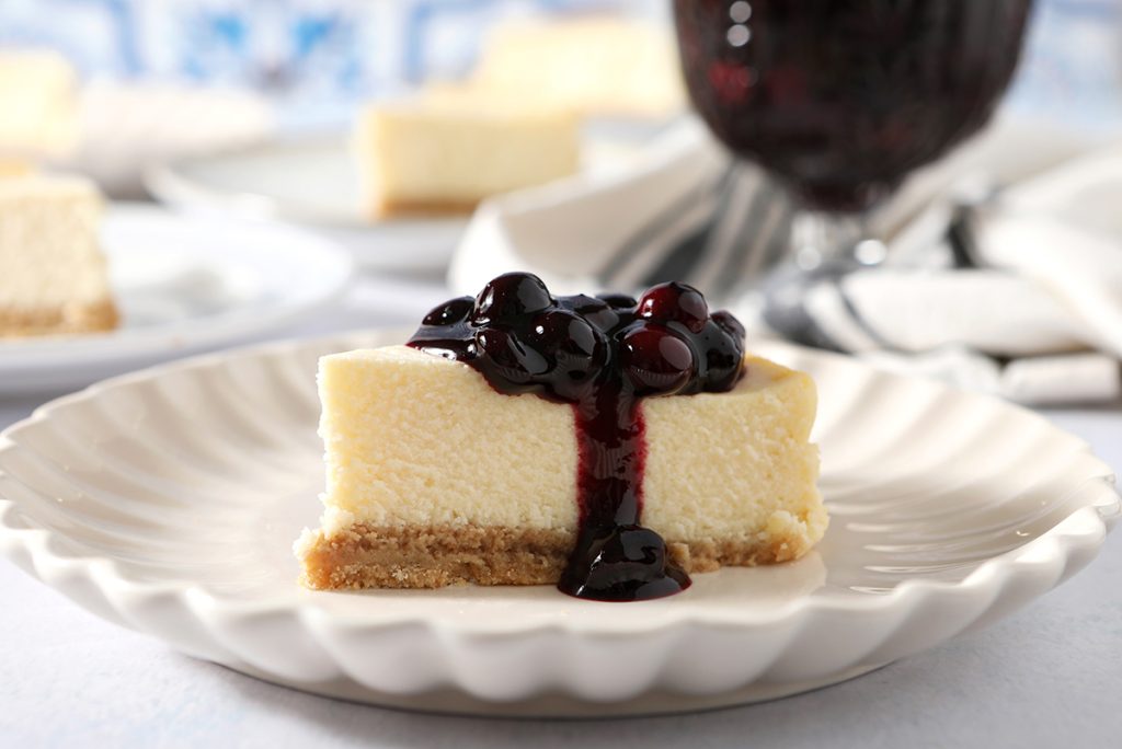 straight on shot of cheesecake with blueberry sauce