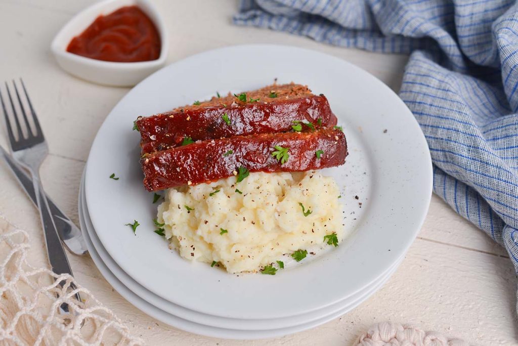 meatloaf slices on plate with mashed potatoes