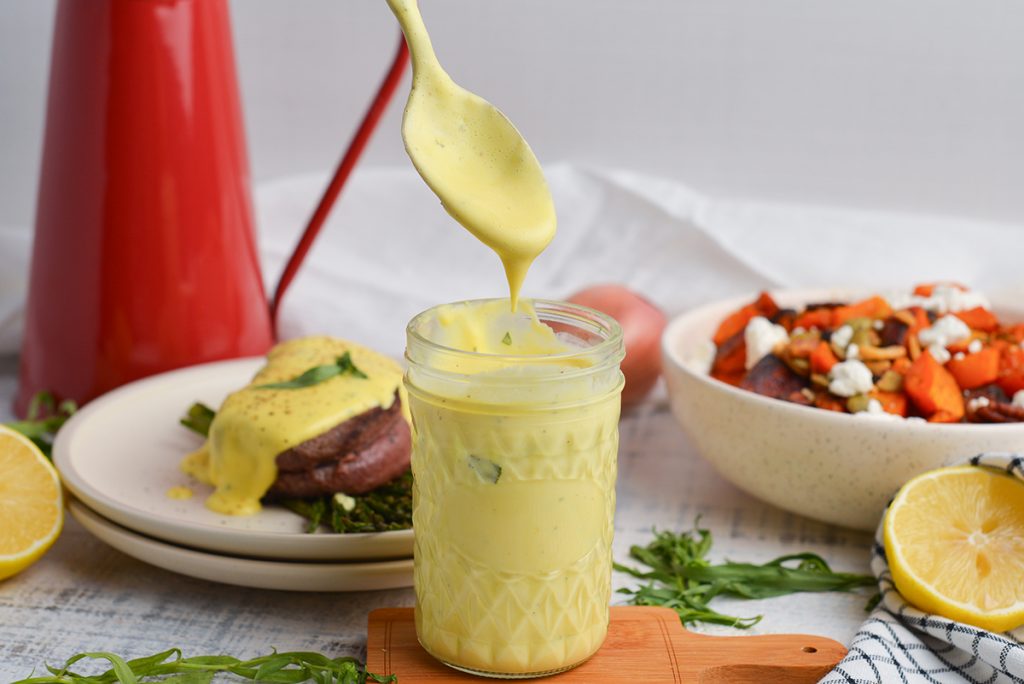 spoon dipping into jar of bearnaise sauce
