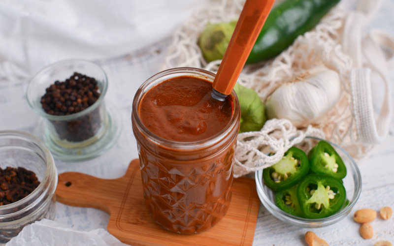 angled shot of spoon in jar of mole sauce