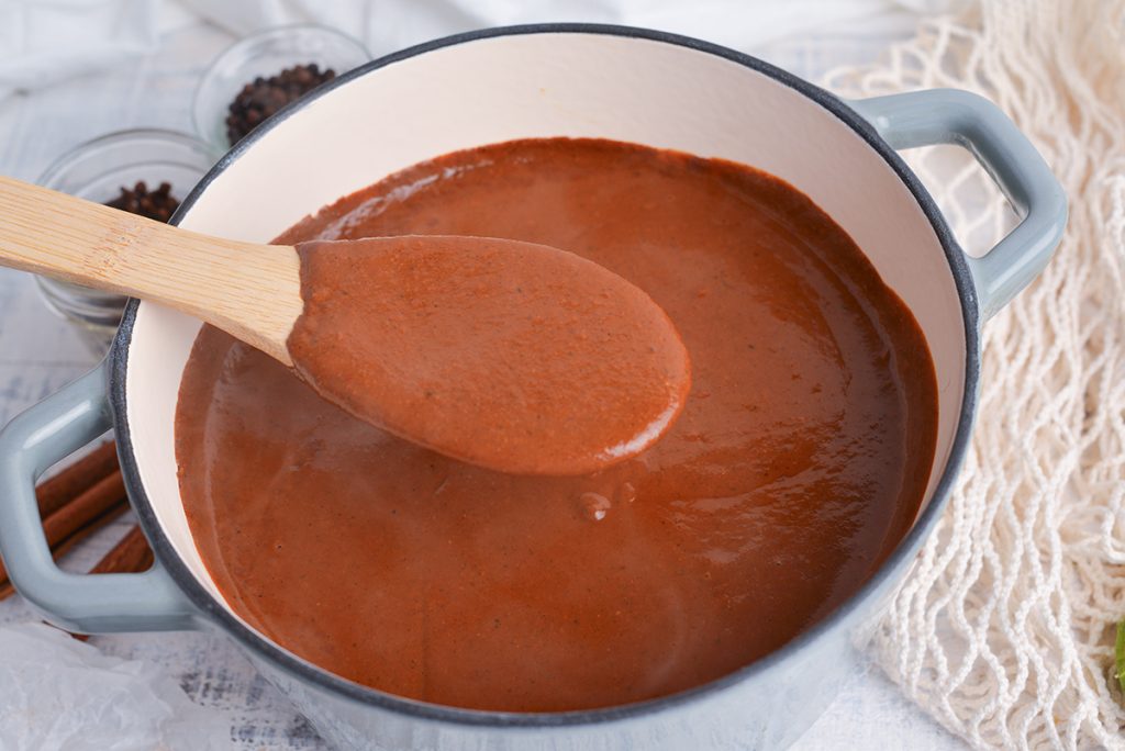 wooden spoon in pan of mole sauce