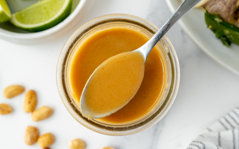 overhead shot of spoon in jar of pad thai sauce