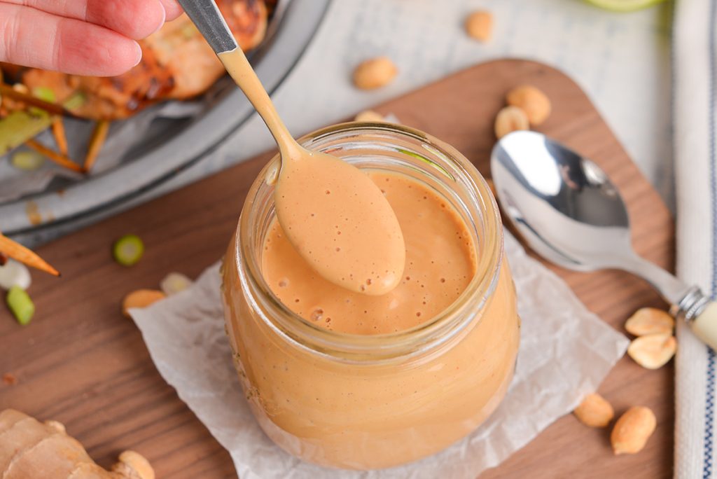 angled shot of spoon in jar of peanut sauce