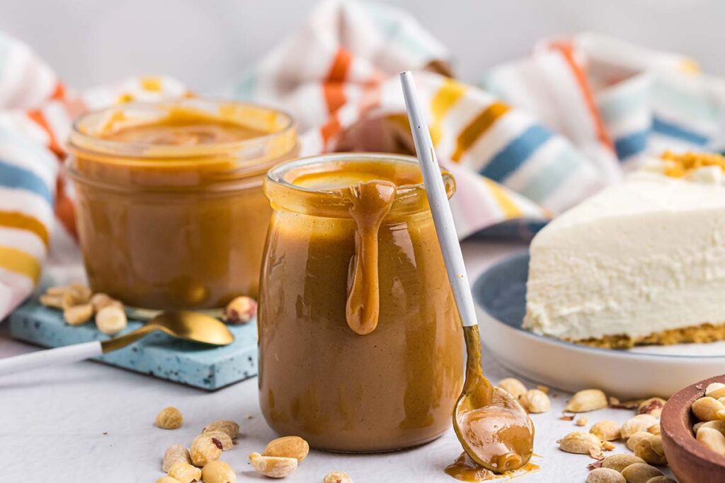 spoon leaning against jar of peanut butter sauce