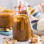 spoon leaning against jar of peanut butter sauce