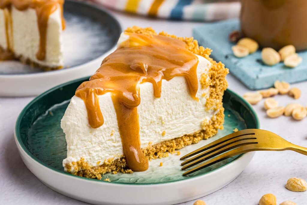 close up of cheesecake drizzled with peanut butter sauce