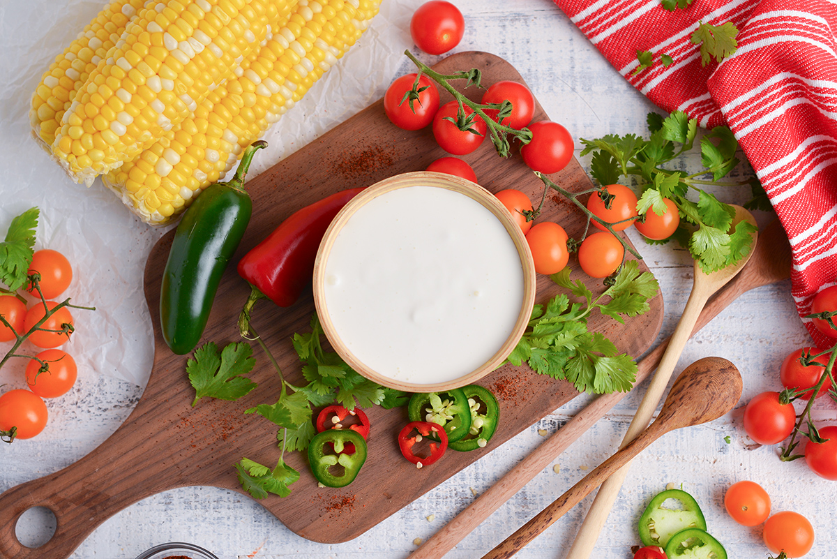 overhead shot of bowl of mexican crema on wooden board