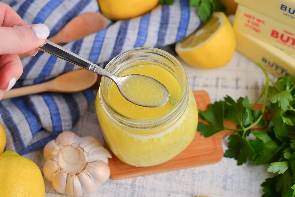 angled shot of spoon in jar of lemon butter sauce