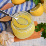 angled shot of spoon in jar of lemon butter sauce