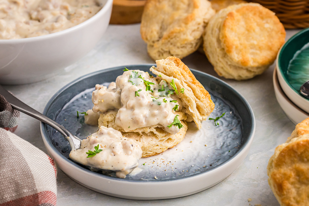 angled shot of country gravy on biscuit with a spoon