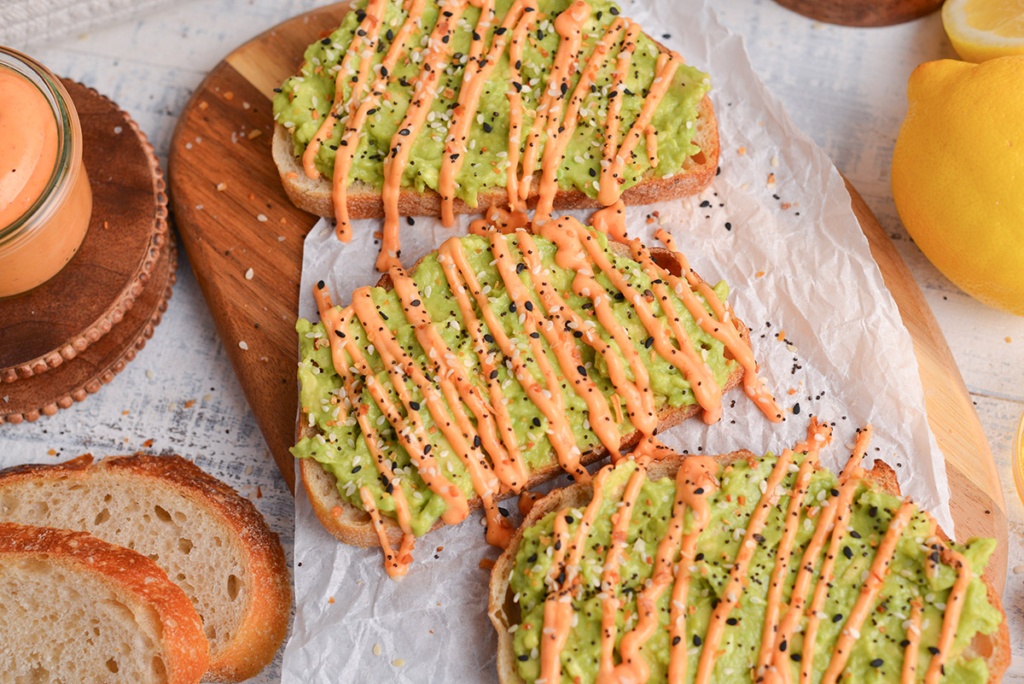 angled shot of sriracha mayo drizzled onto avocado toast