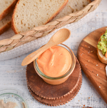 angled shot of jar of sriracha mayo with wooden spoon