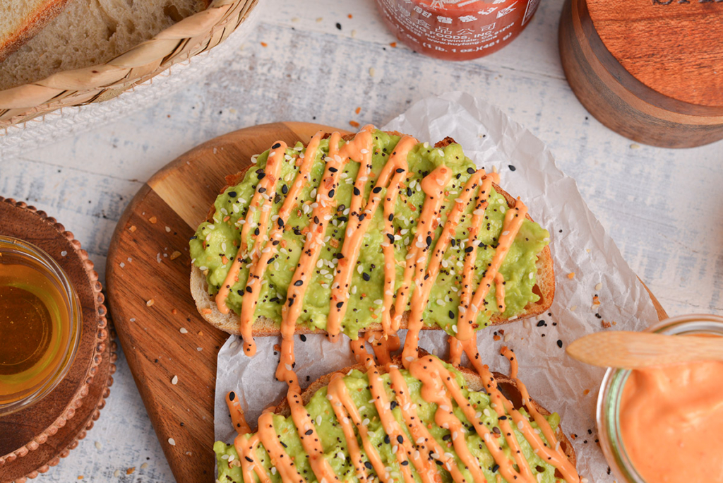 overhead shot of avocado toast drizzled with sriracha mayo