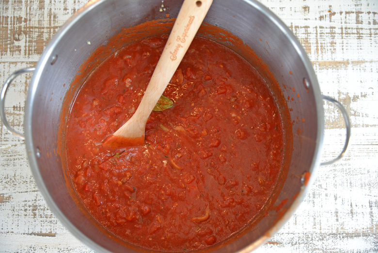 sunday gravy stirring in a pot