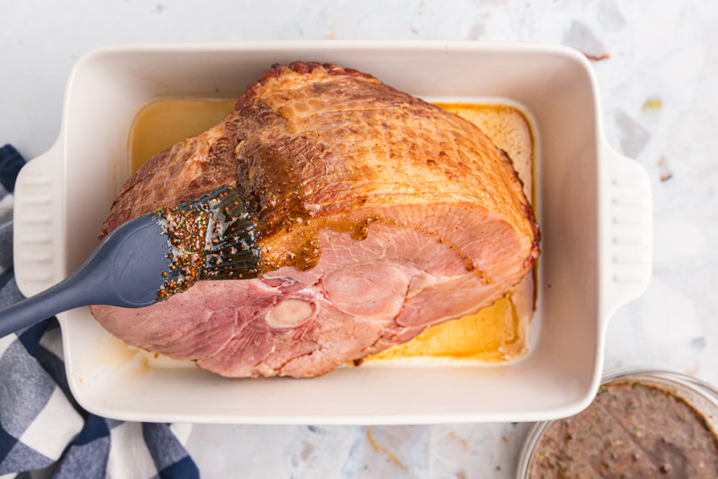 overhead shot of brush adding ham glaze to ham