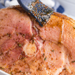 brushing basting glaze onto sliced ham