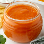 angled shot of jar of homemade enchilada sauce