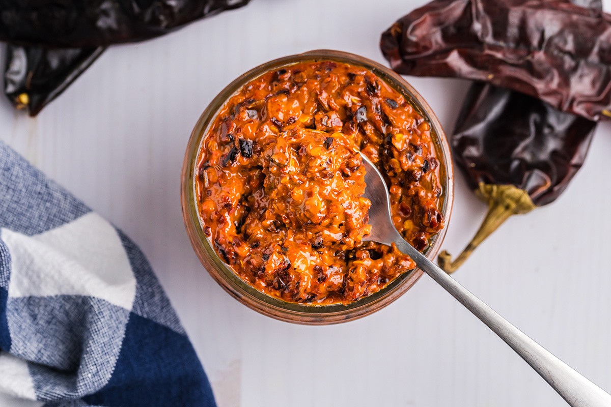 overhead shot of spoon in jar of harissa sauce