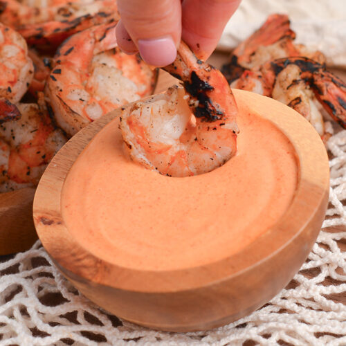 shrimp dipping in bowl of yum yum sauce