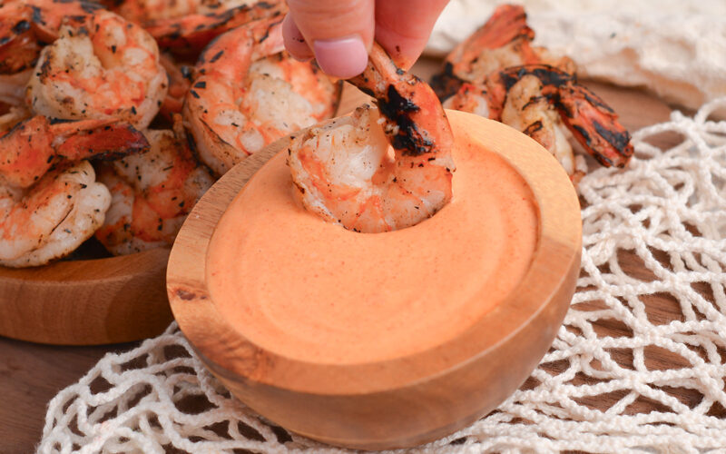 shrimp dipping in bowl of yum yum sauce