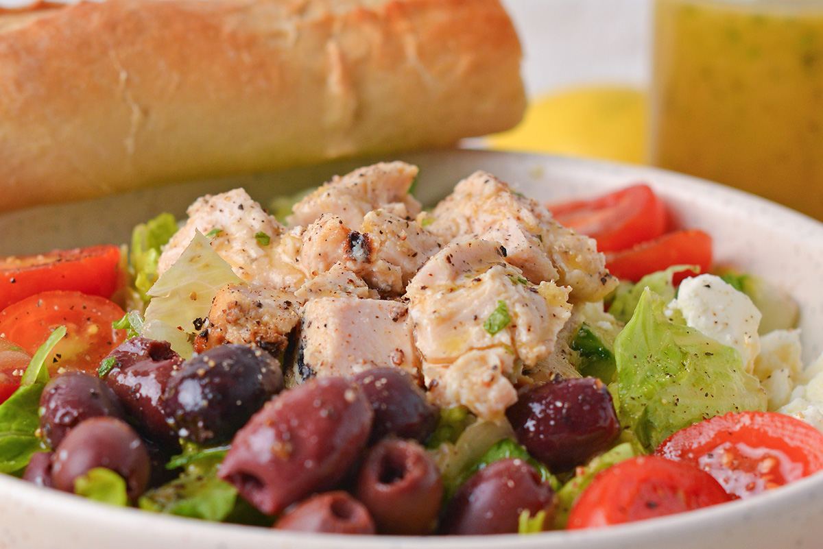 close up shot of chicken on greek salad