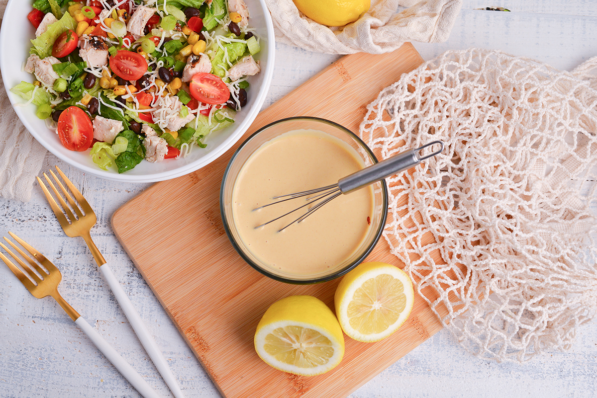 overhead shot of whisk in bowl of honey mustard dressing