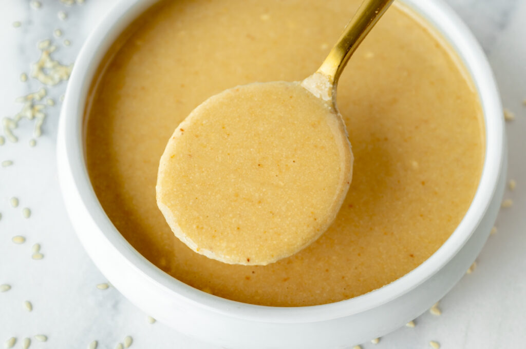 angled shot of spoon in bowl of tahini