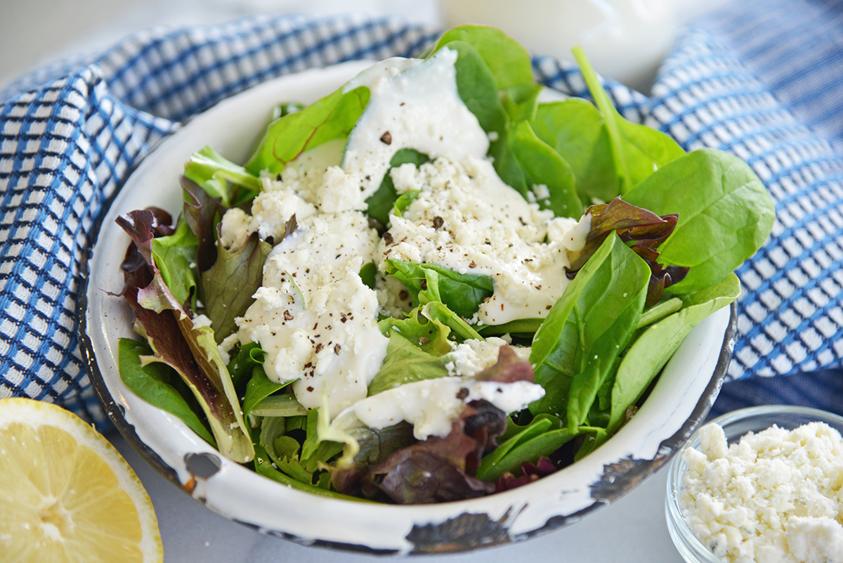 angled shot of salad topped with blue cheese dressing