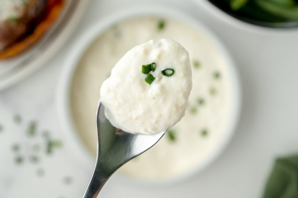 overhead shot of spoon of creamy horseradish sauce