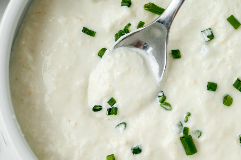 close up shot of spoon in bowl of horseradish cream sauce