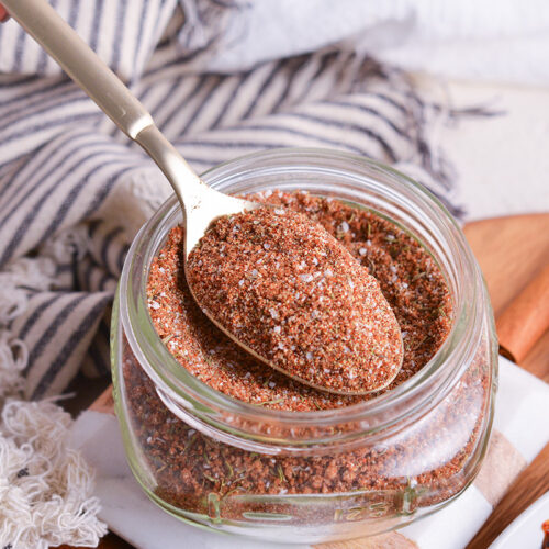 close up angled shot of spoon in jar of jerk seasoning