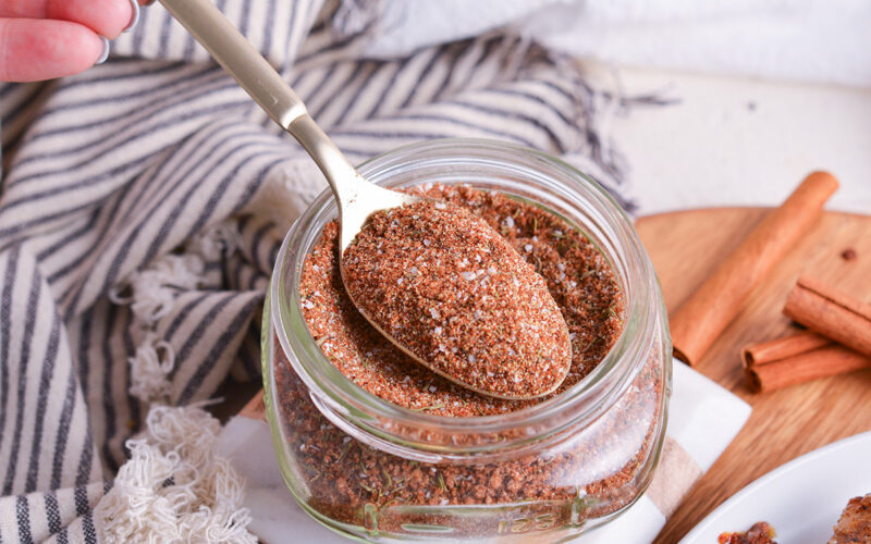 close up angled shot of spoon in jar of jerk seasoning