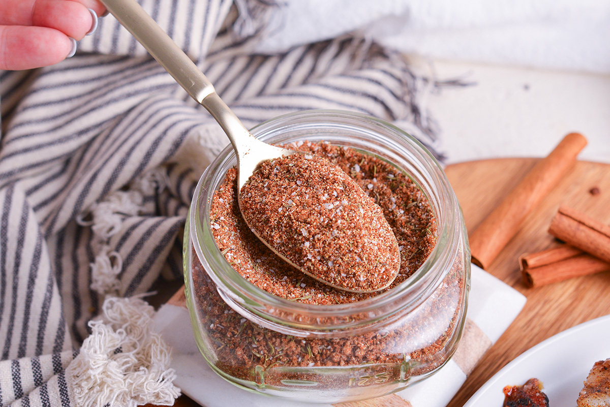 close up angled shot of spoon in jar of jerk seasoning