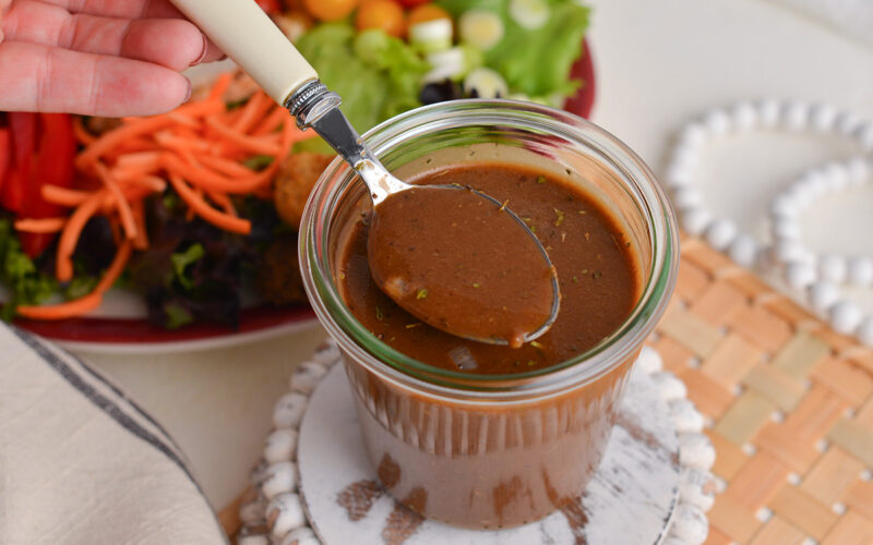 angled shot of spoon in jar of balsamic vinaigrette