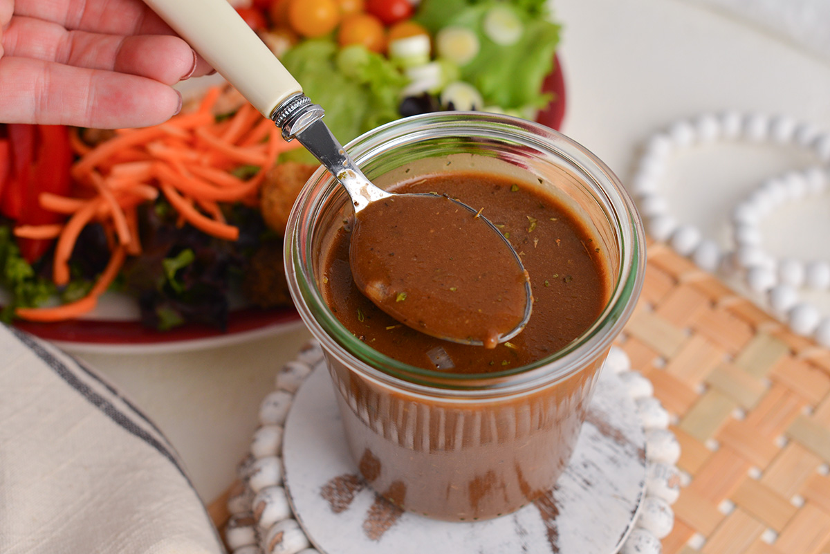 angled shot of spoon in jar of balsamic vinaigrette