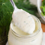 close up of spoon in jar of creamy greek dressing