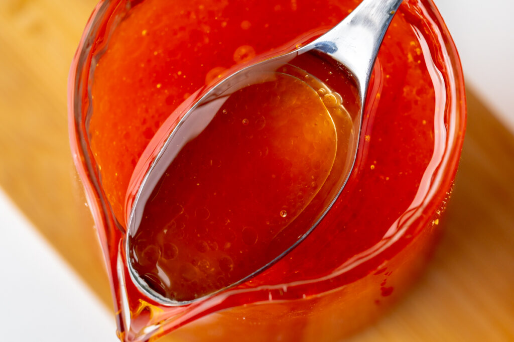 close up of spoon in jar of french dressing