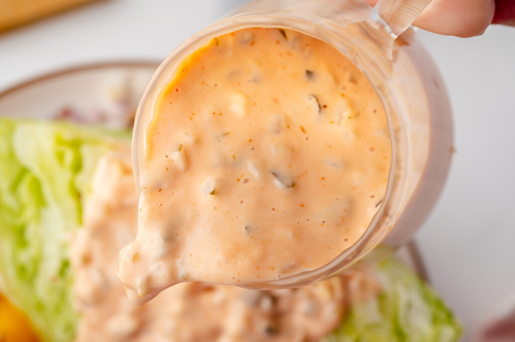 close up of dressing poured over salad