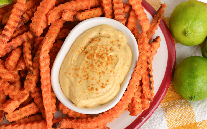 close up overhead shot of bowl of curry mayo with sweet potato fries