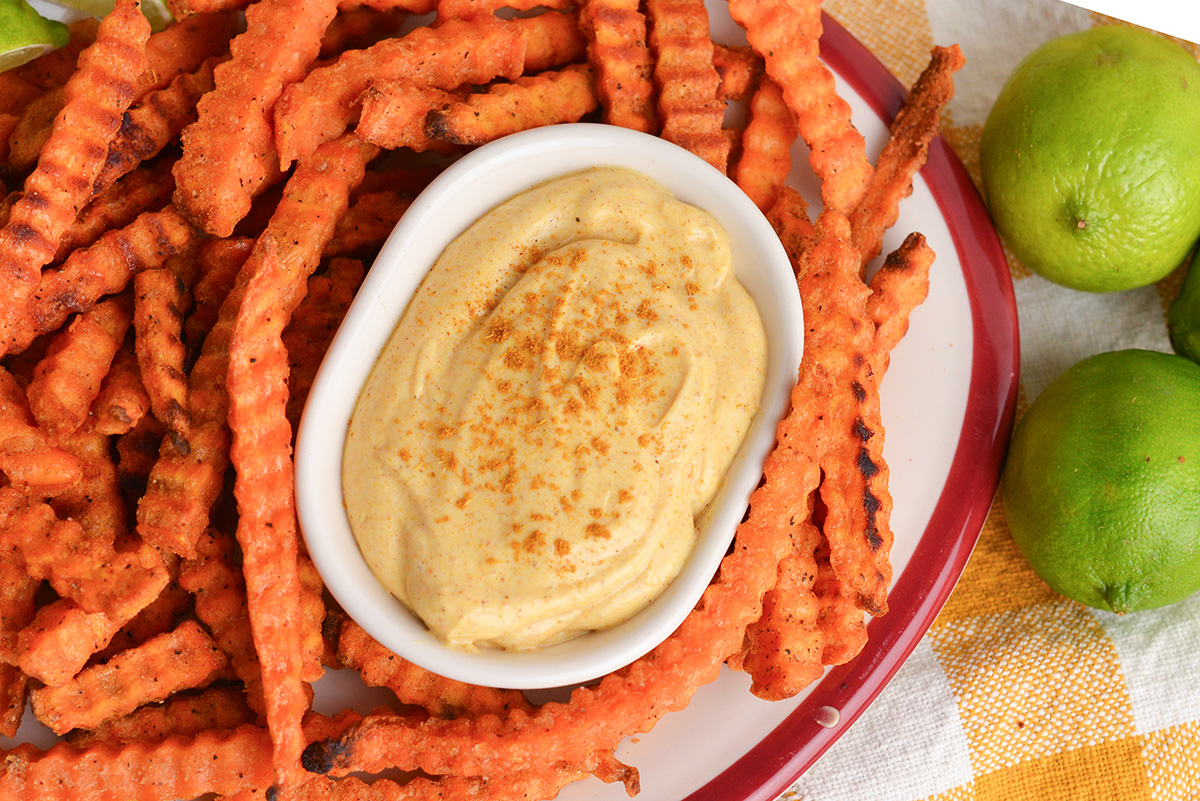 close up overhead shot of bowl of curry mayo with sweet potato fries