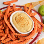 angled shot of bowl of curry mayo with sweet potato fries