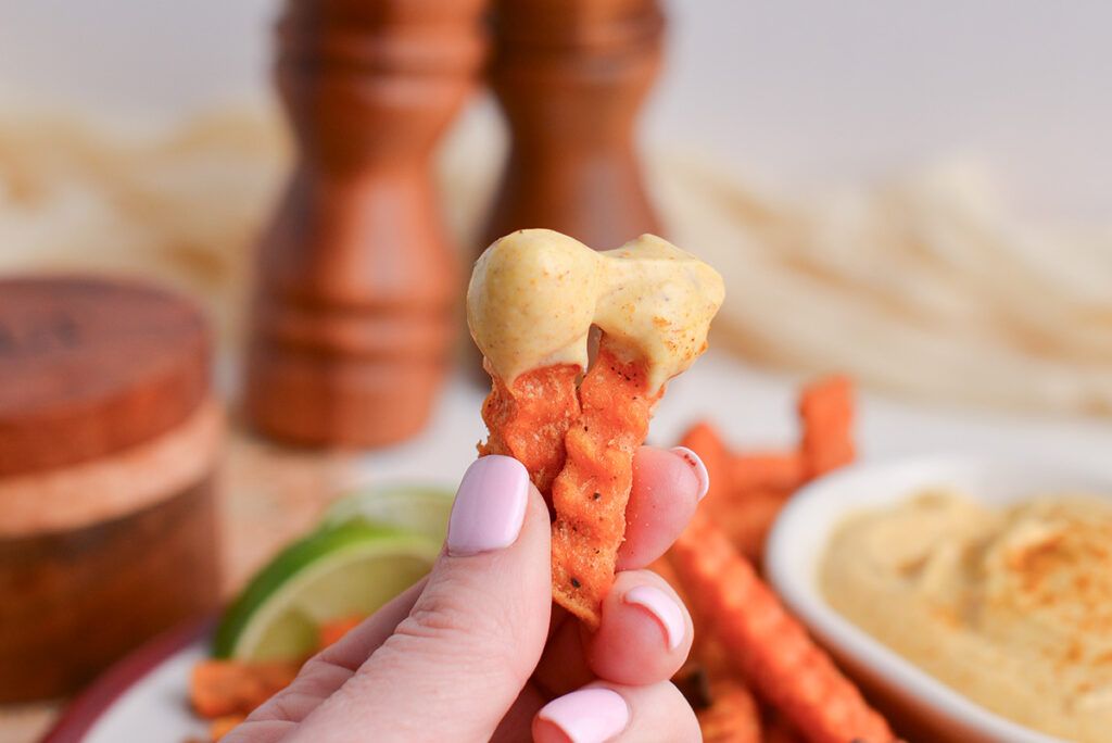 two sweet potato fries dipped into curry mayo