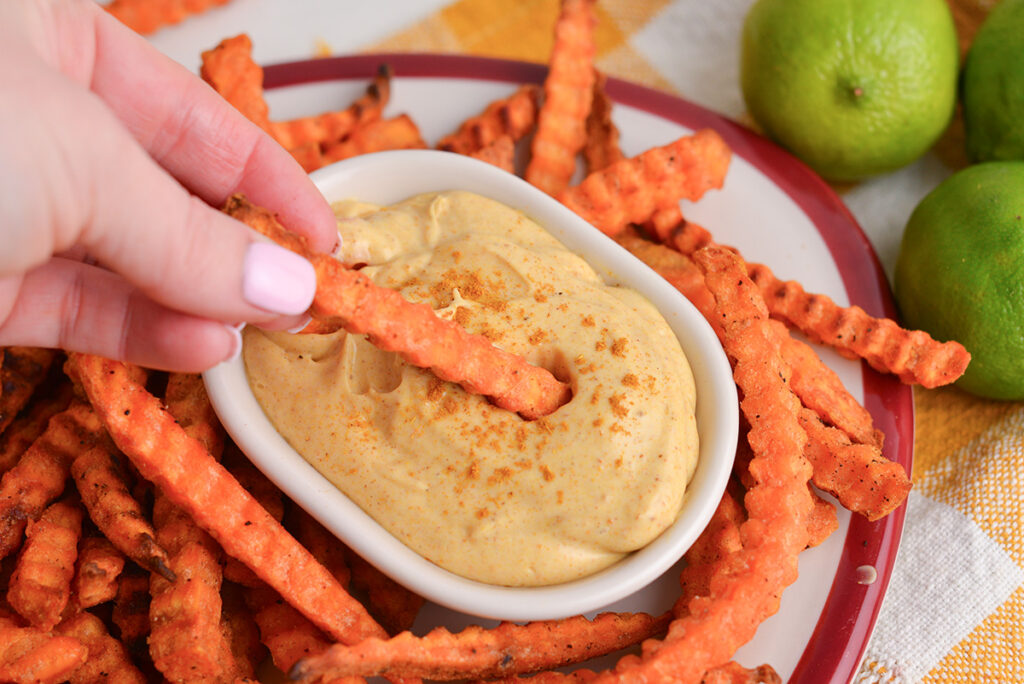 sweet potato fry dipping into curry mayo