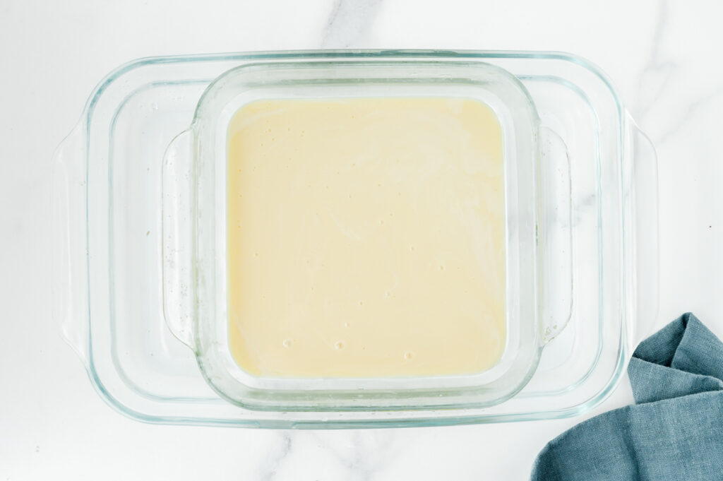 overhead shot of pan of sweetened condensed milk in water bath