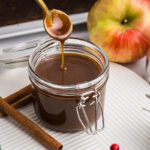 spoon dipping into jar of gingerbread caramel sauce