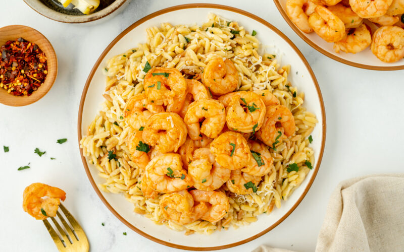 overhead shot of marinated shrimp over orzo