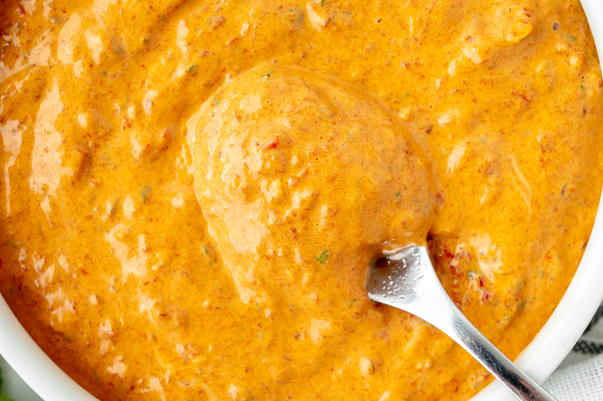 overhead shot of spoon in bowl of chipotle mayo