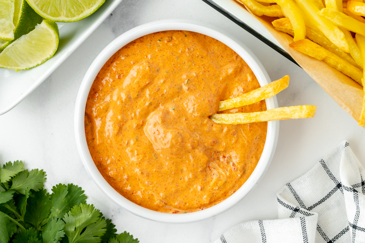 overhead shot of two fries in bowl of sauce