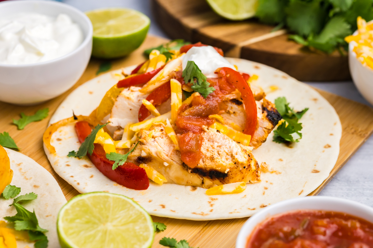 angled shot of chicken fajita on board